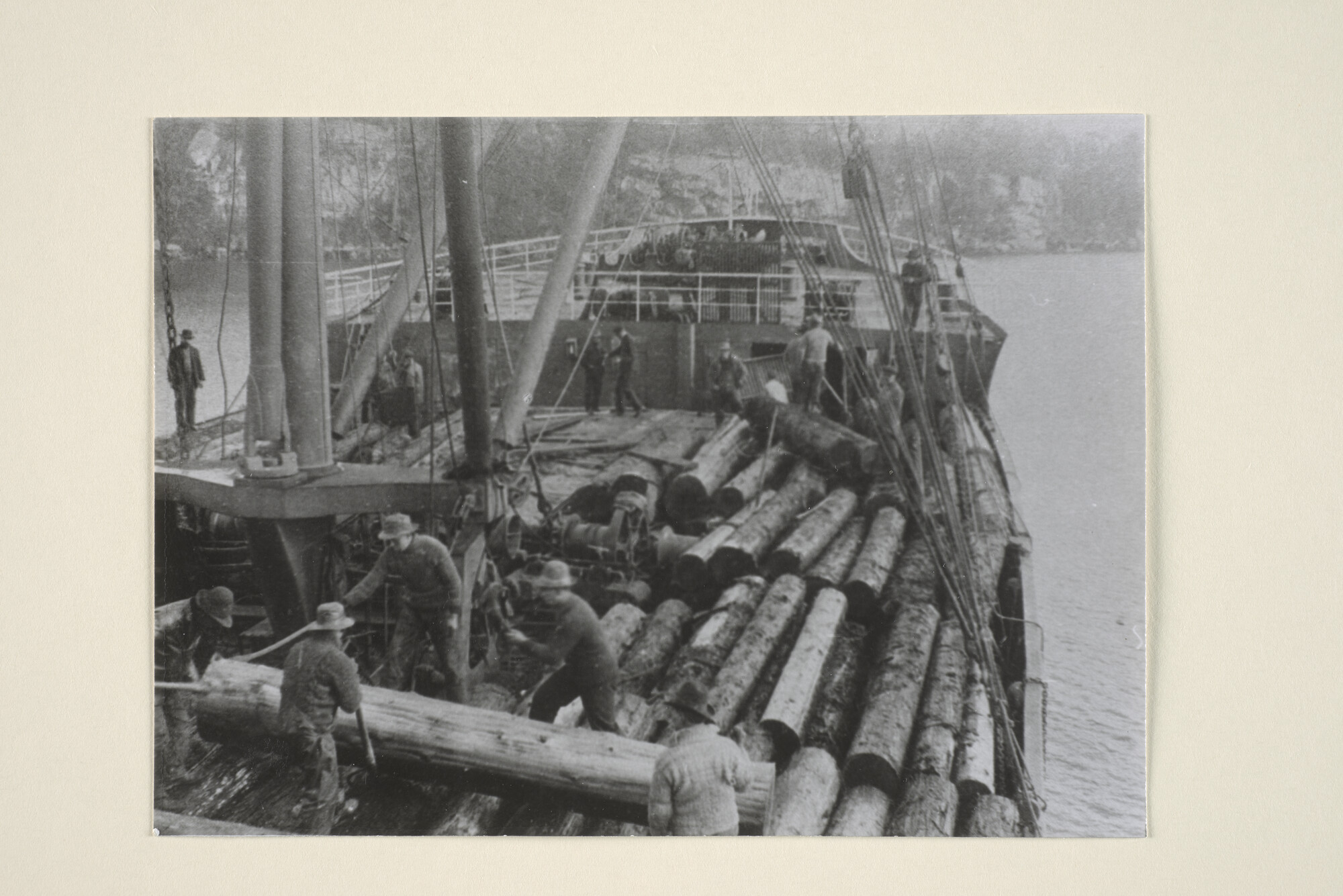 1995.1760; Indiaanse bootwerkers laden de deklast van "cedar logs" aan boord van het vrachtschip Bintang van de SMN; foto