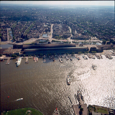 S.9100(7183); Havengezicht te Amsterdam met het IJ. Luchtfoto. Dia (tegenlichtopname) van het IJ en Centraal Station; diapositief