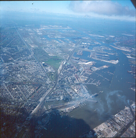 S.9100(7833); Dia (luchtfoto) van het Westelijk Havengebied van Amsterdam gezien vanaf de stad; diapositief