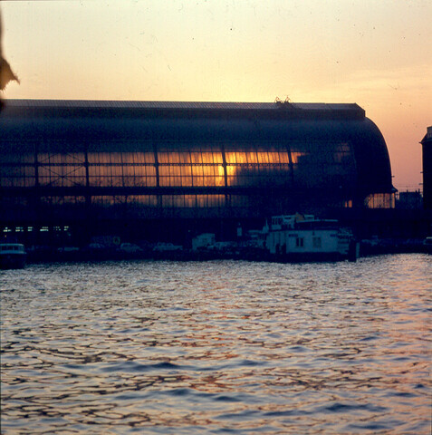 S.9100(2868); Dia van het Centraal Station Amsterdam, achterkant bij avond; diapositief