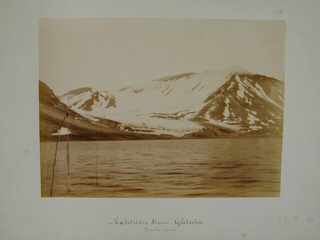 S.3986(01); Map met een verzameling losse foto's gedeeltelijk met onderschrift van de zevende Noordpoolexpeditie van de Willem Barents in 1884; fotoalbum