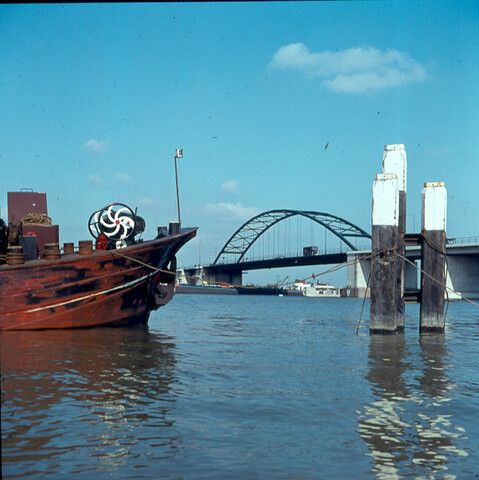 S.9100(1368); Dia brug over Buiten-IJ, met 3 meerpalen en boeg van binnenschip; diapositief