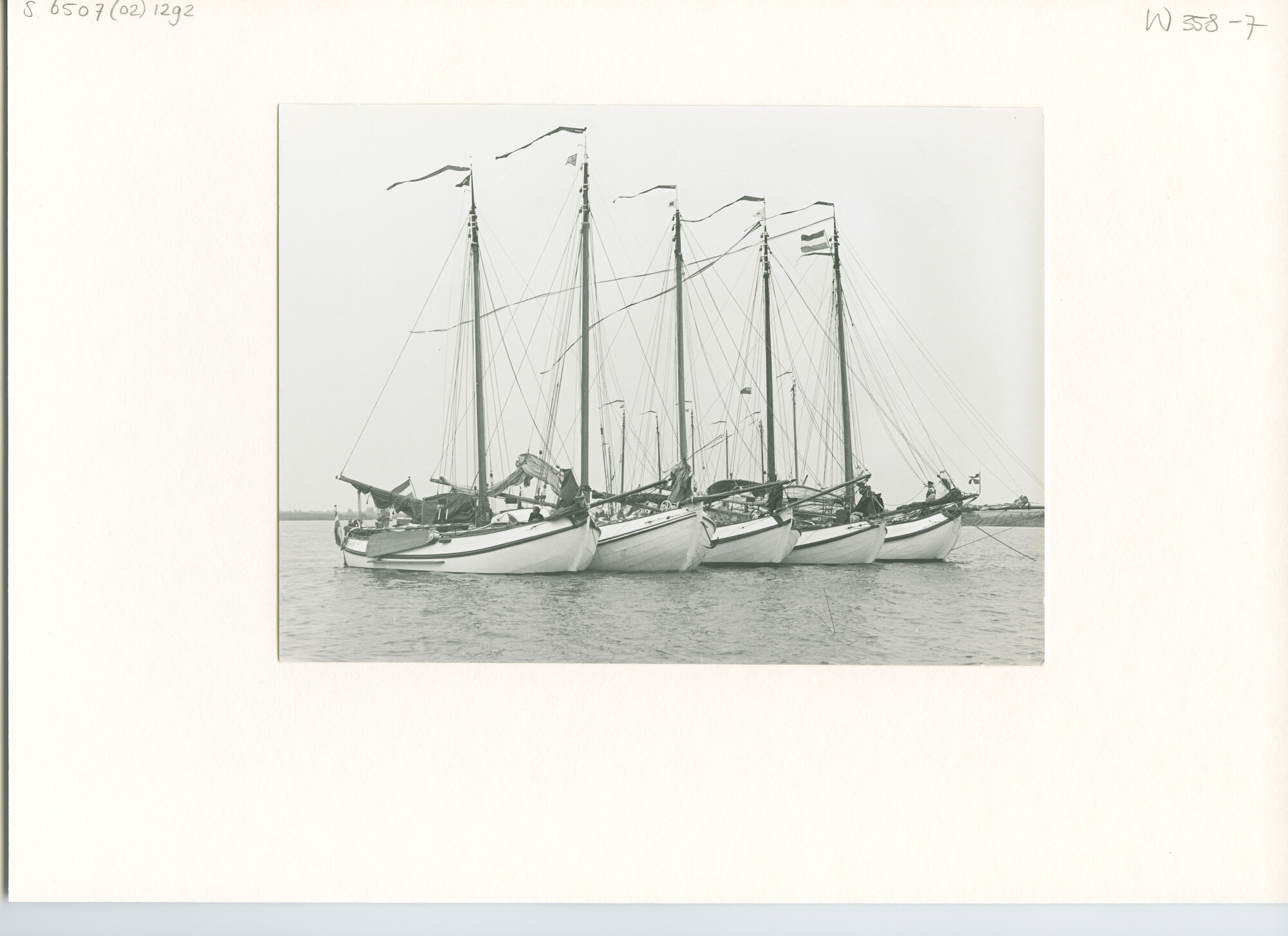 S.6507(02)1292; Zwart-wit foto van de reünie van ronde en platbodemjachten op de Beulakerwijde: lemsteraken voor anker op het meer; foto