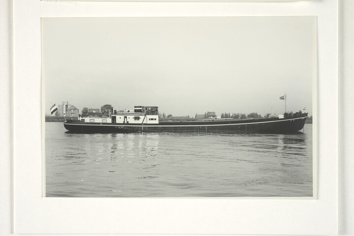 S.5219(12)0705; Foto's van het vrachtschip ms. Roekwijk van de Nieuwe Rijnvaart Maatschappij op een rivier en aan een kade; fotoreportage