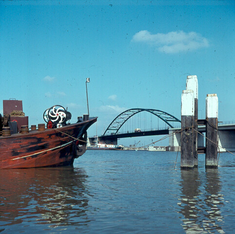 S.9100(1367); Dia brug over buiten IJ, met 3 meerpalen en boeg van binnenschip; diapositief