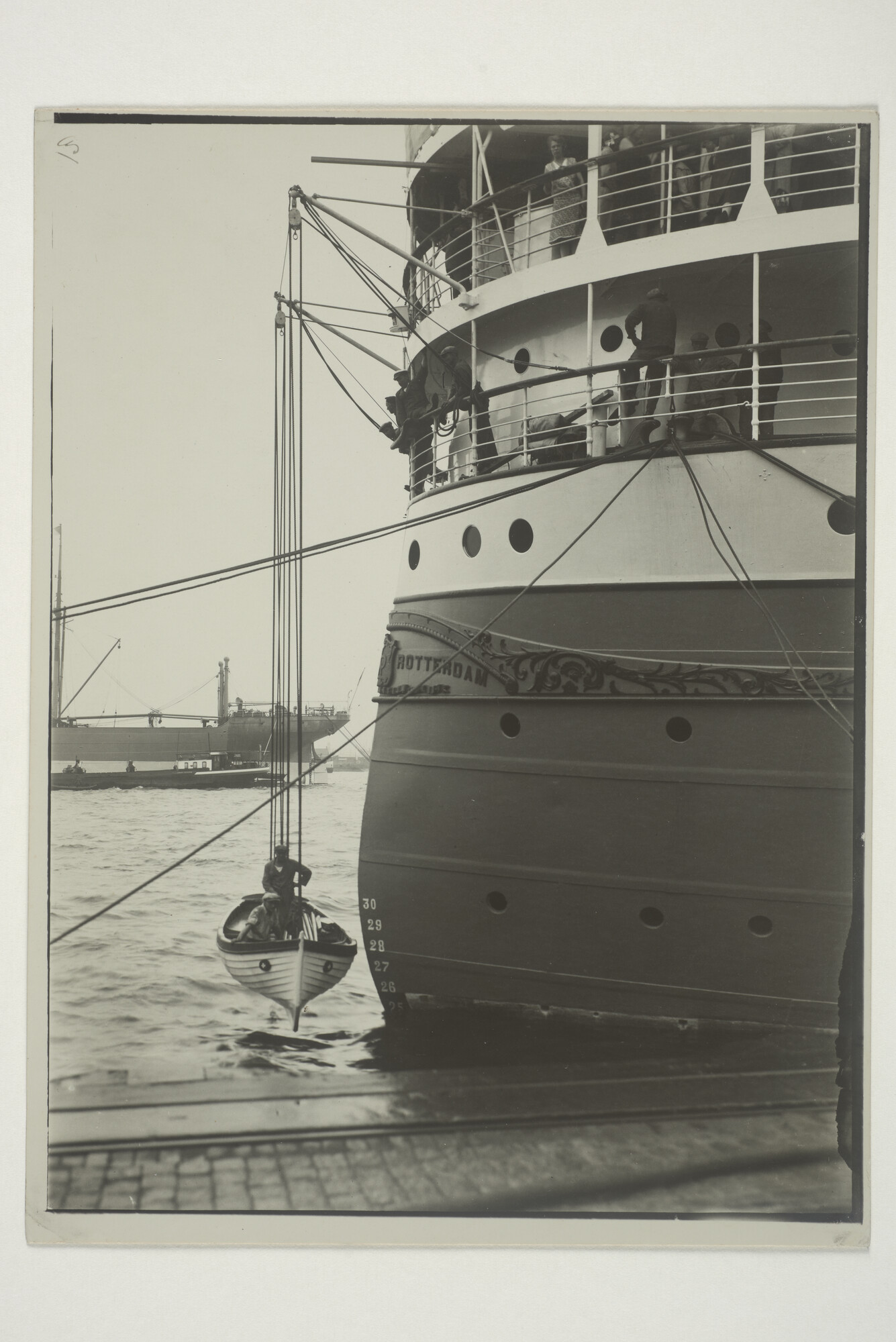 1999.1512; Zeelieden strijken een sloepje achterop het mailschip ms. 'Indrapoera' van de Rotterdamsche Lloyd, omstreeks 1935; foto
