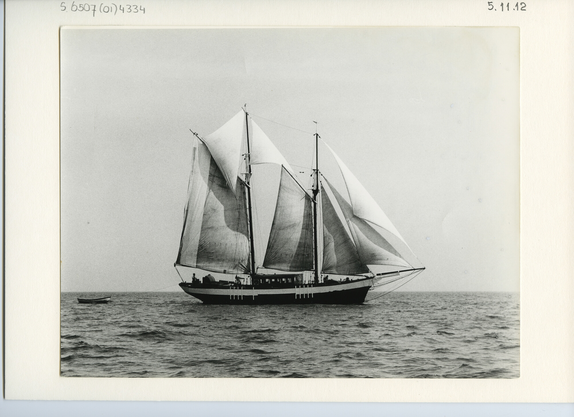 S.6507(01)4334; Een houten gaffelschoener met zwarte romp zeilend met ruime wind op zee; foto