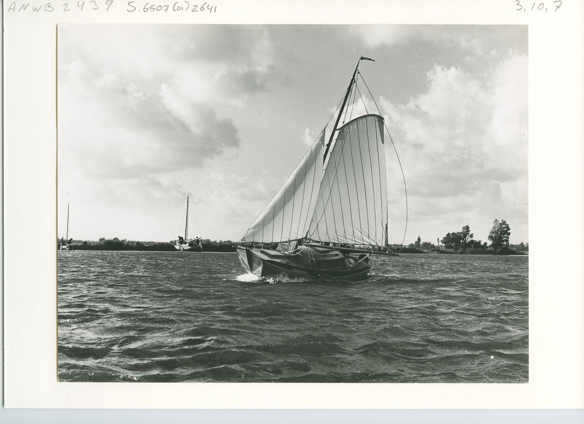 S.6507(01)2641; Zijgezicht van een schouw met kajuit hoog aan de wind over een meer; foto