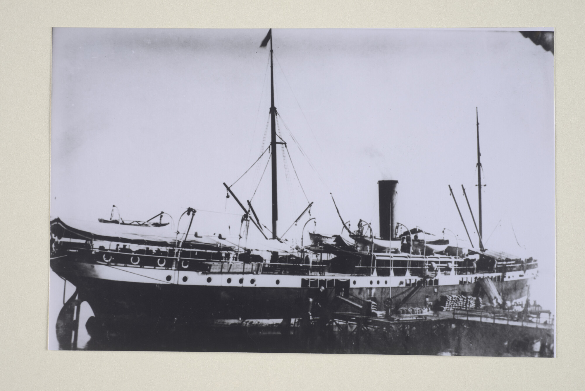 1994.1889; Het ss. 'Van Swoll' ligt aan een steiger in Nederlands Indië en bezig met het laden en lossen van goederen; foto