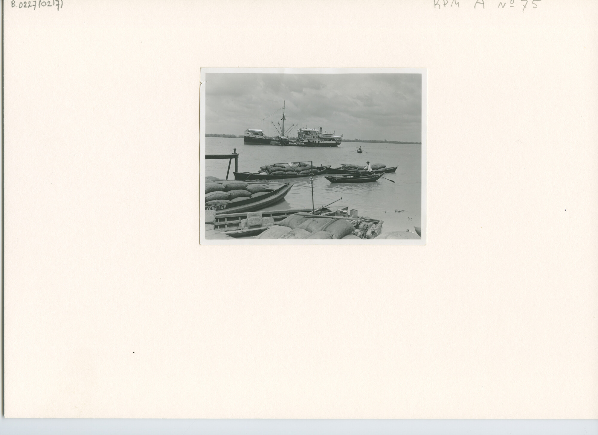 B.0227(0217); Foto van de coaster ms. Majang aan de monding van de Indriagiri-rivier met op de voorgrond met zakken beladen prauwen; foto