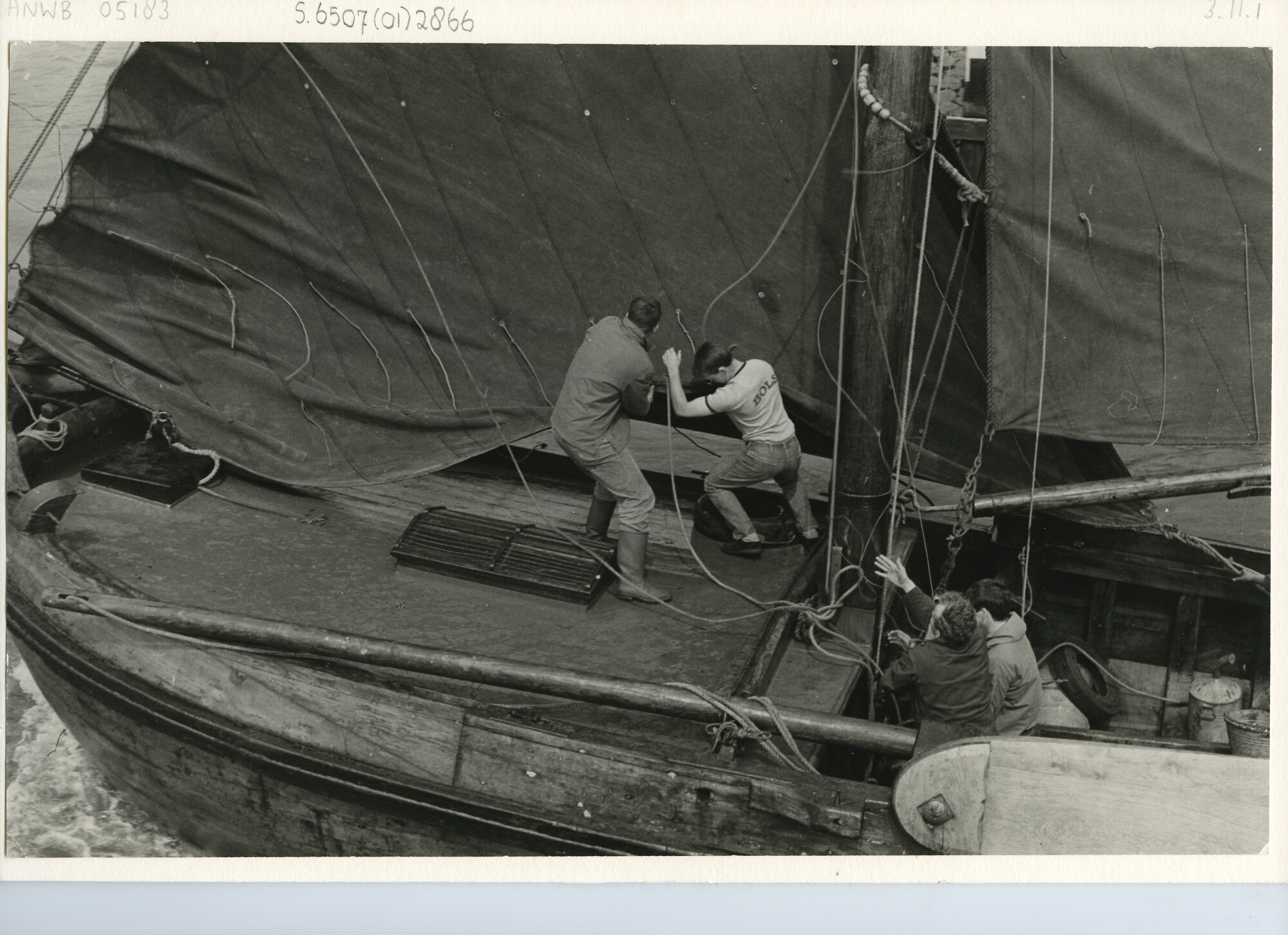 S.6507(01)2866; Het door twee man neerhalen van de fok aan boord van een botter; foto