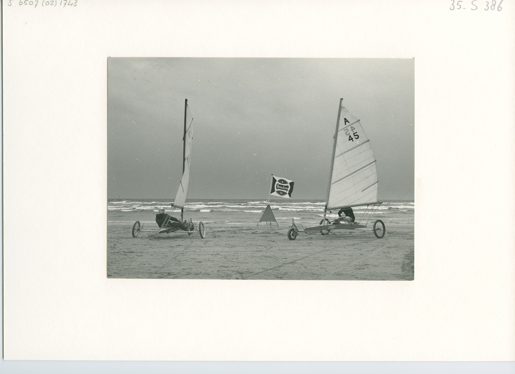 S.6507(02)1743.04; Zwart-wit foto van een wedstrijd voor zeilwagens op het strand in 1965; foto