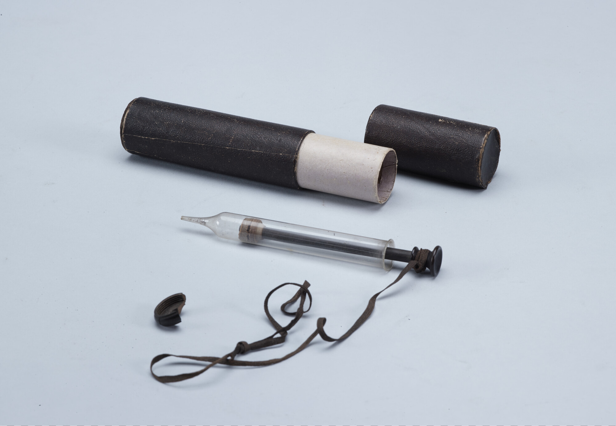 A.5168(03); Injectiespuit van glas (klisteerspuit) in kartonnen koker; spuit