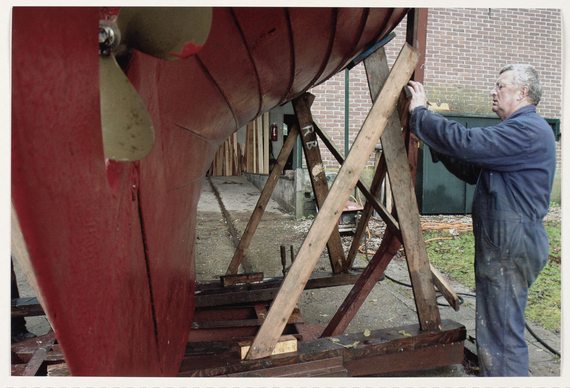2012.0850; Kleurenfoto van Nico Bakker werkend aan de bok onder de Thor II bij scheepswerf Kroes in Kampen; foto