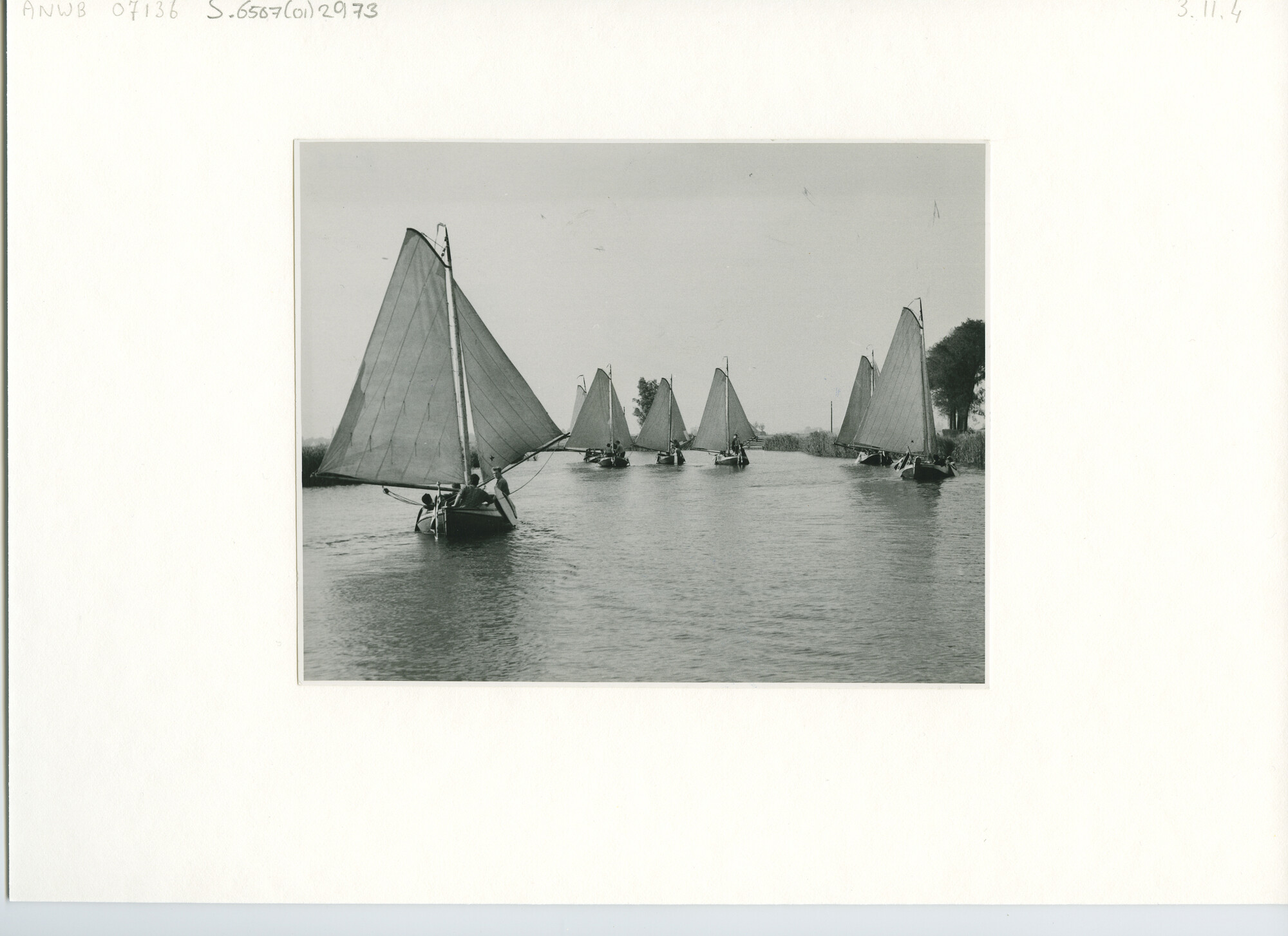 S.6507(01)2973; Zeven tjotters zeilen voor de wind over een vaart; foto