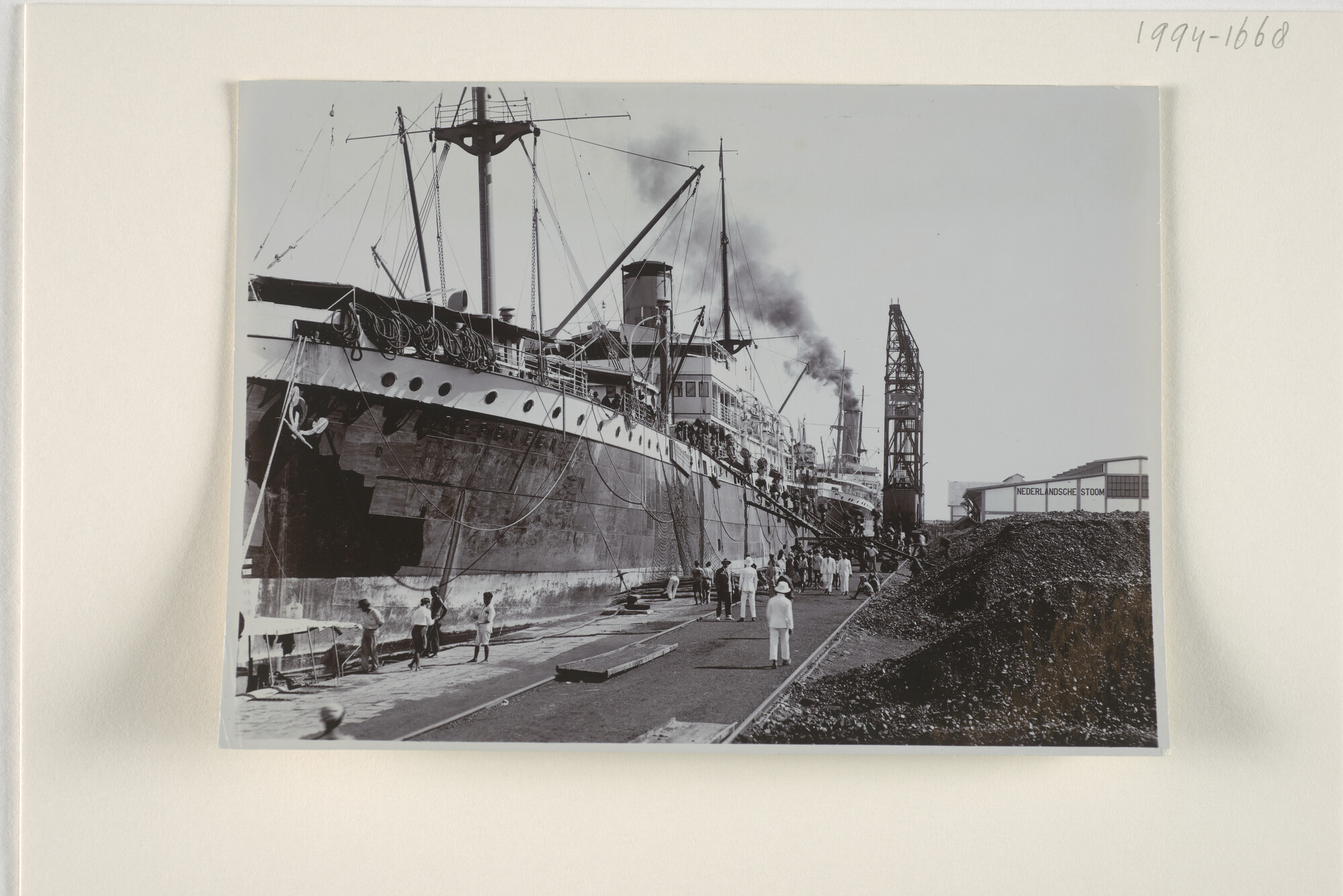 1994.1668; Het ss. 'Roggeveen' afgemeerd aan de kade te Makassar tijdens het bunkeren van steenkool, juni 1928; foto