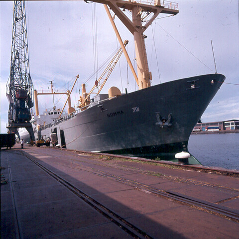 S.9100(6357); Side Loading. Dia Noorse vrachtschip ms. 'Bomma' van Fred Olsen & Co afgemeerd in de Coenhaven te Amsterdam [...]; diapositief