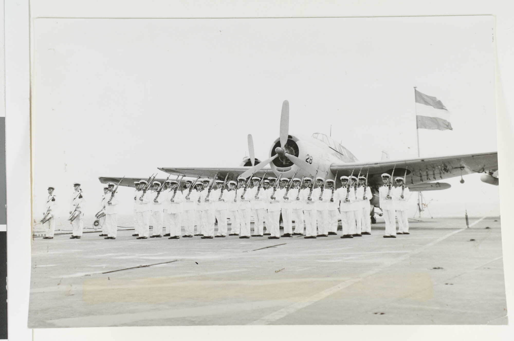 1992.1597; De erewacht van de gewapende wacht gevormd door mariniers aangetreden op het achterdek van het vliegkampschip Hr.Ms. 'Karel Doorman' (R 81) [...]; foto