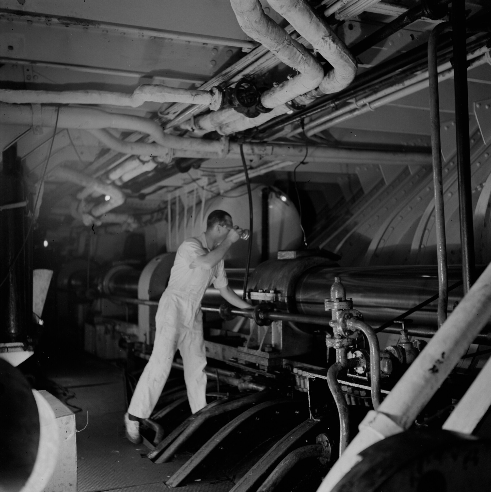 2015.1669; Negatief van een werktuigbouwkundige die de schroefas in de machinekamer van ms Johan van Oldenbarnevelt inspecteert; negatief