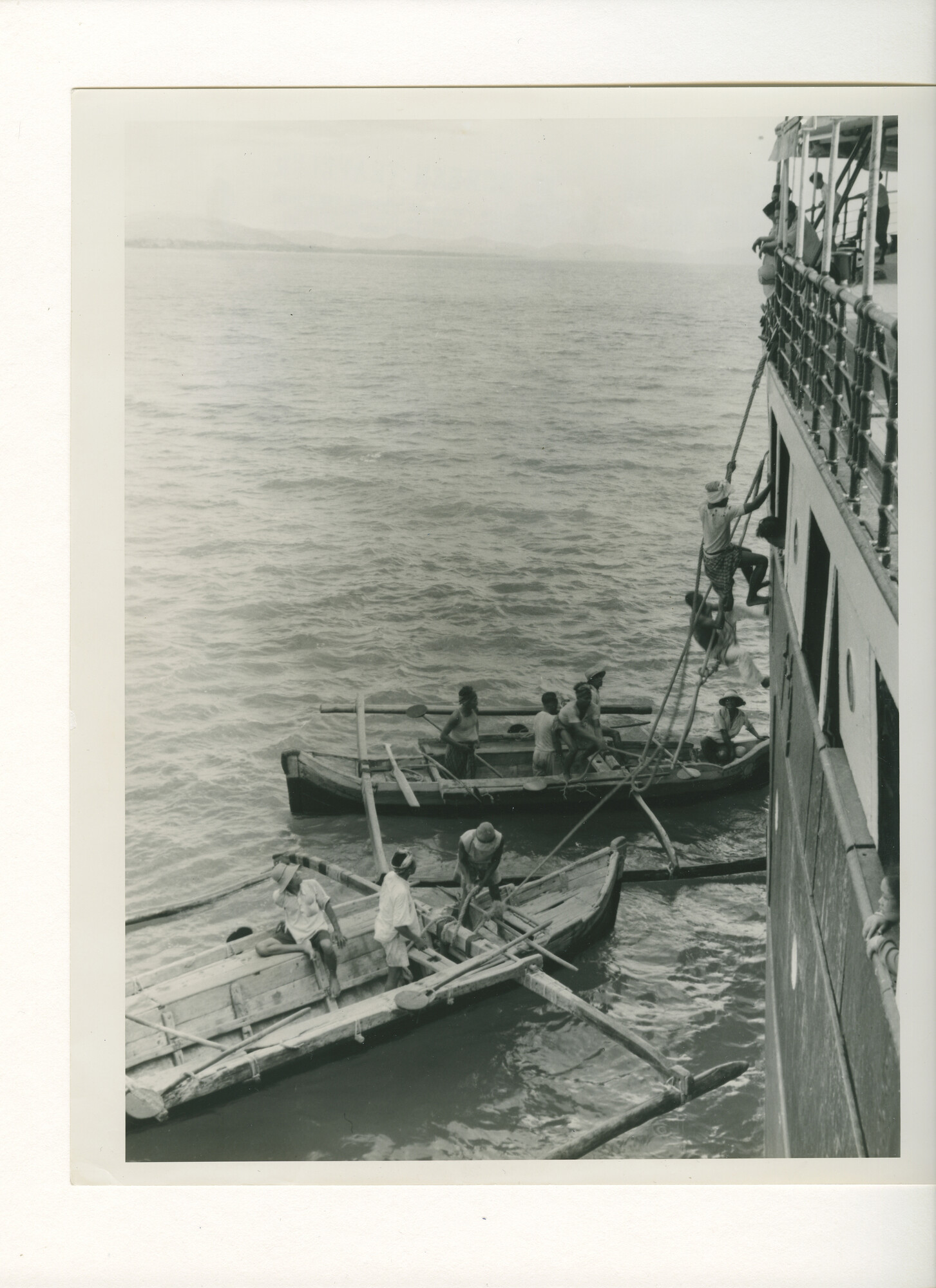 B.0227(1711); Foto van schip in Ampenan; mensen klimmen via een ladder aan boord van het schip; foto