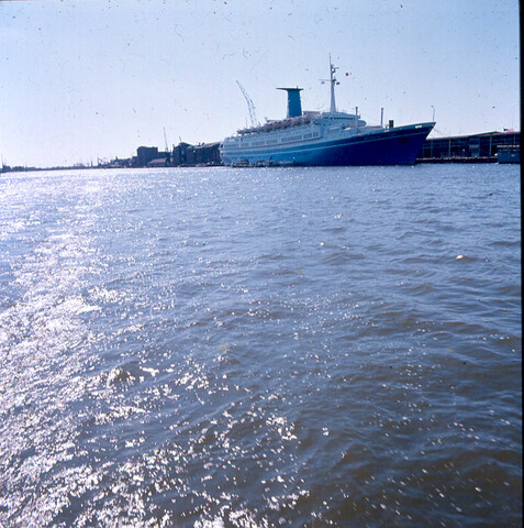 S.9100(7014); Dia van het Italiaanse cruiseschip Angelino Lauro (ex- Oranje van de SMN) afgemeerd bij de PTA in Amsterdam; diapositief