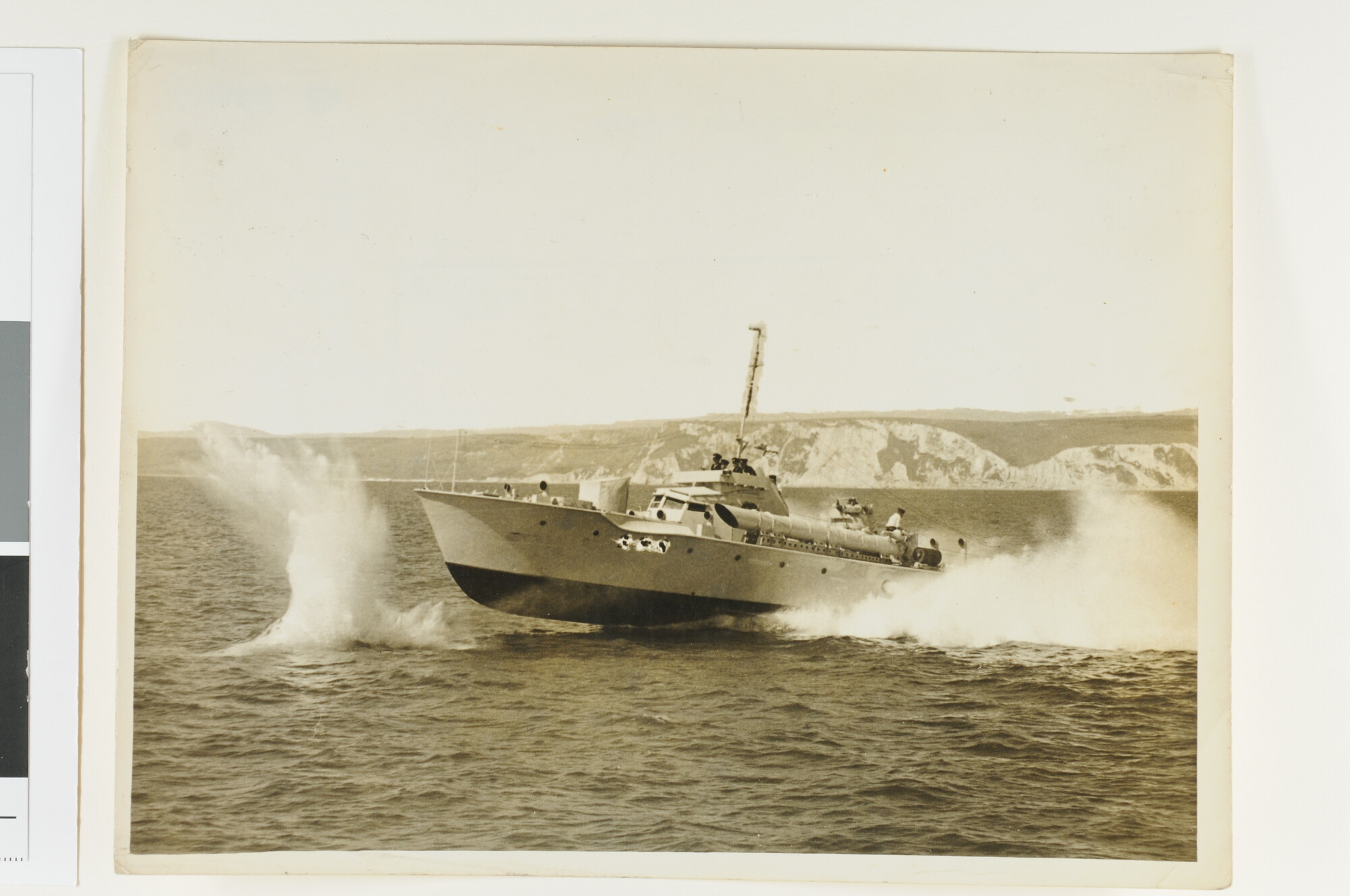 S.4872(04)07; Een (Nederlandse) MTB, type Vosper, vuurt een torpedo af in de nabijheid van de Britse kust; foto