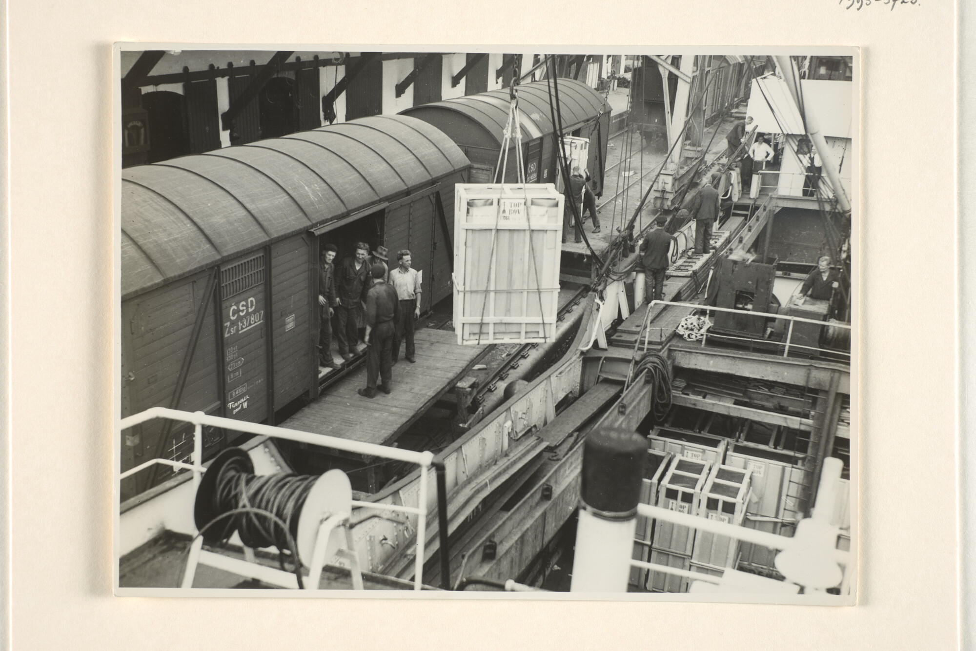 1995.5725; Het laden van houten kratten uit een vrachtschip in een goederentrein ergens [...]; foto