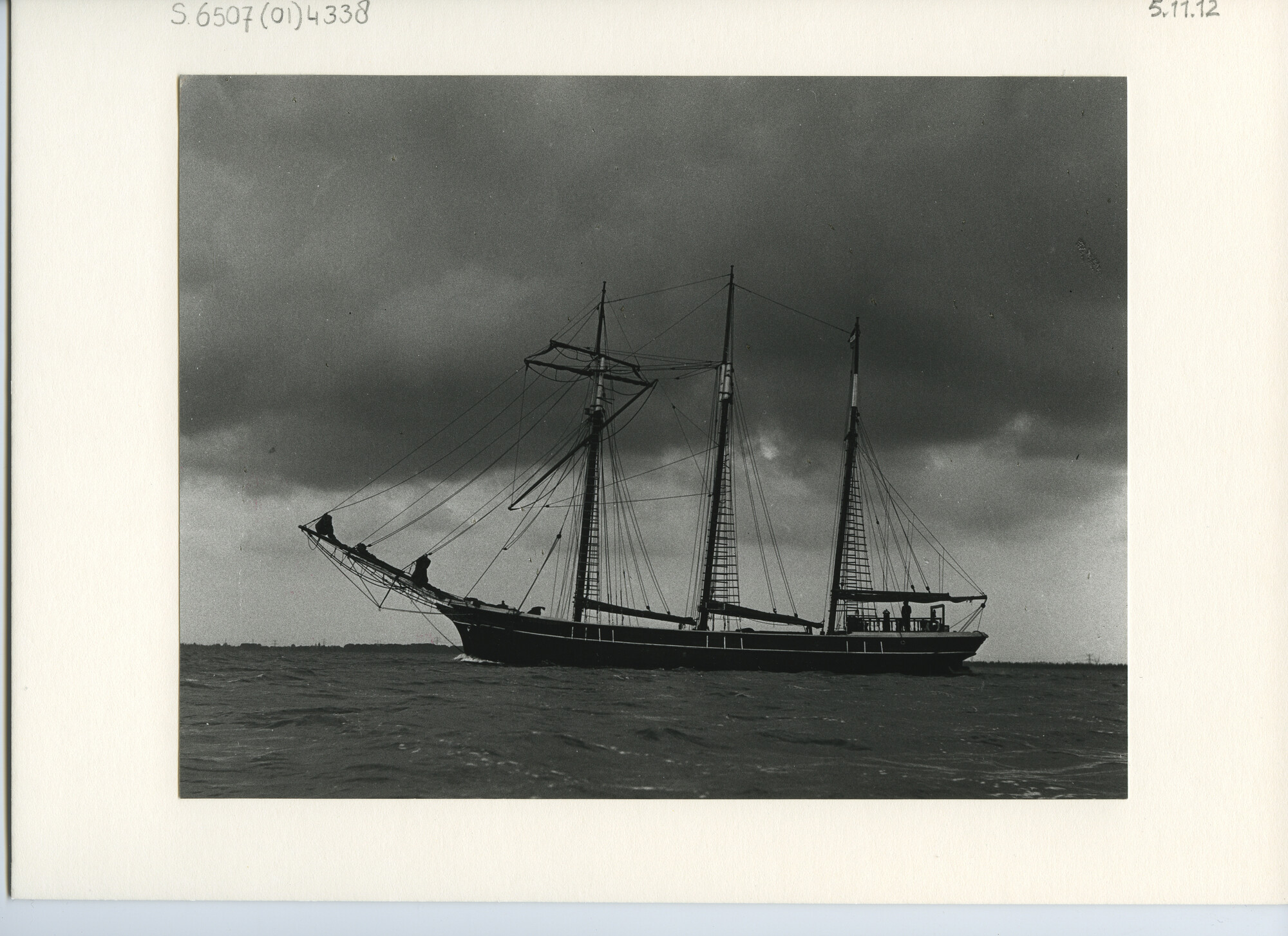 S.6507(01)4338; Foto van de Britse houten driemasttopzeilschoener Kathleen & May (1900) met donkere romp varend op ruim water; foto