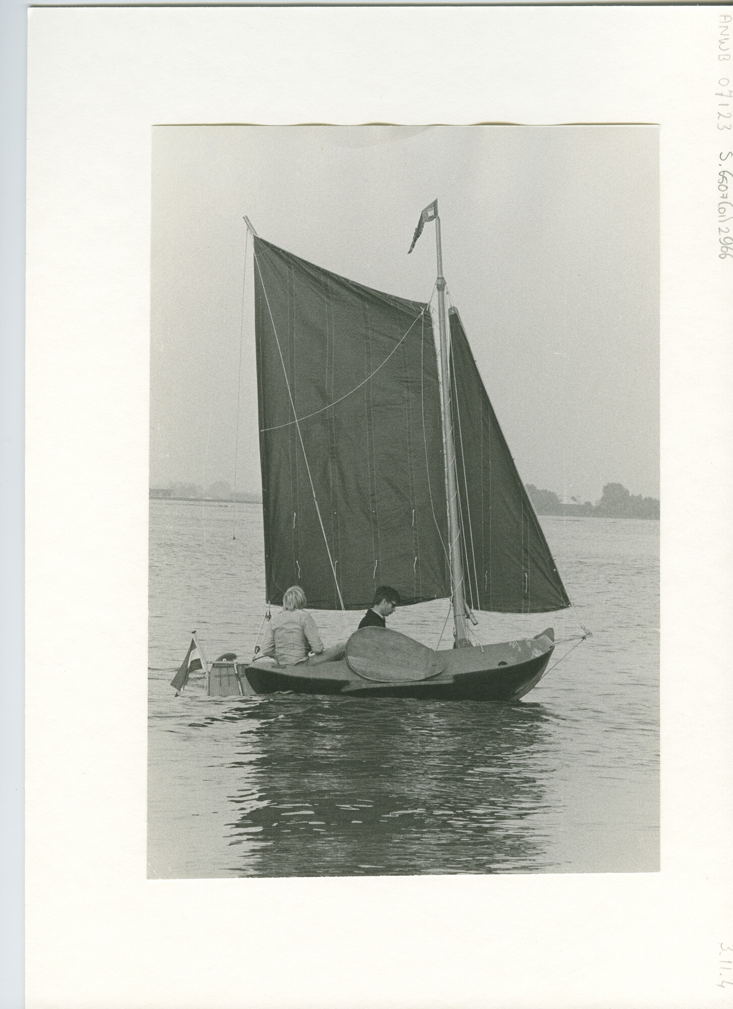 S.6507(01)2966; Zijaanzicht over stuurboord van een kleine tjotter met een spriettuig zeilend met twee bemanningsleden op een meer; foto