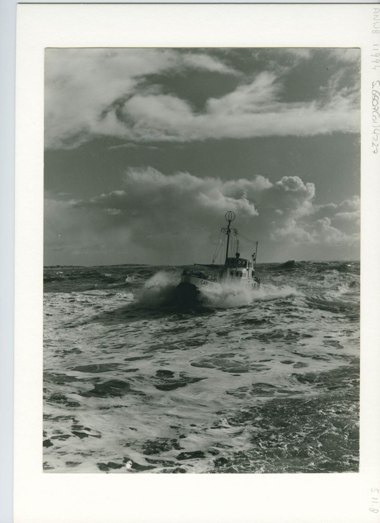 S.6507(01)4227; Foto van de motorreddingboot Carlot van de KNZHRM varend op ruwe zee met een duinenrij op de achtergrond; foto