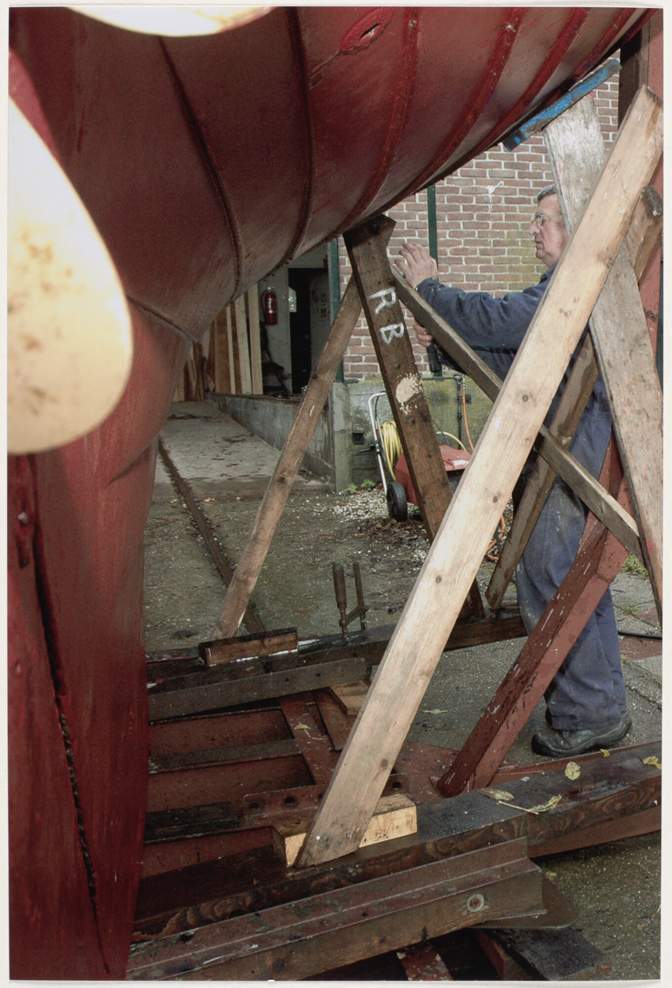 2012.0851; Kleurenfoto van Nico Bakker werkend aan de bok onder de Thor II bij scheepswerf Kroes in Kampen; foto
