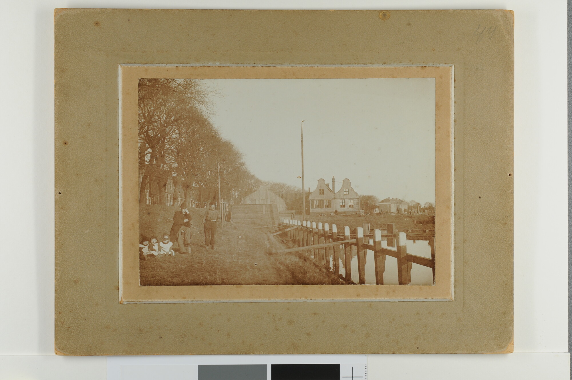 S.7166(22); Nieuwendam en de scheepswerf 'Het Jacht' gezien vanaf de sluis met poserende bewoners op de dijk; foto