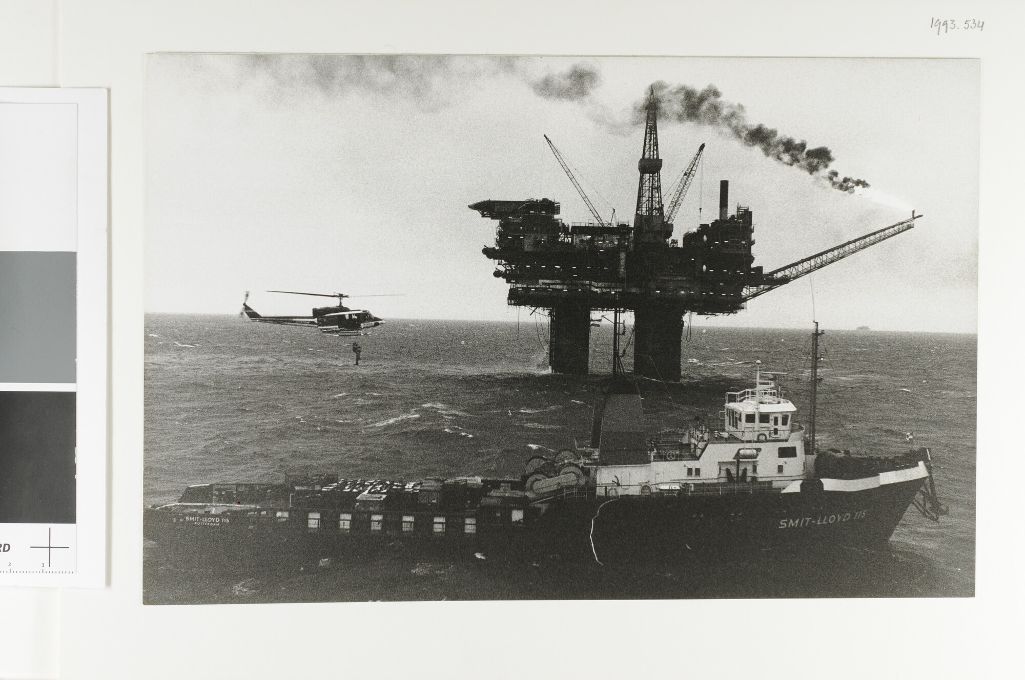 1993.0534; 'Flying Docters of the North Sea.' Het ophijsen van een patient door een civiele helikopter (Augusta Bell) vanaf de 'Smit Lloyd 115' van Smit Lloyd BV; foto