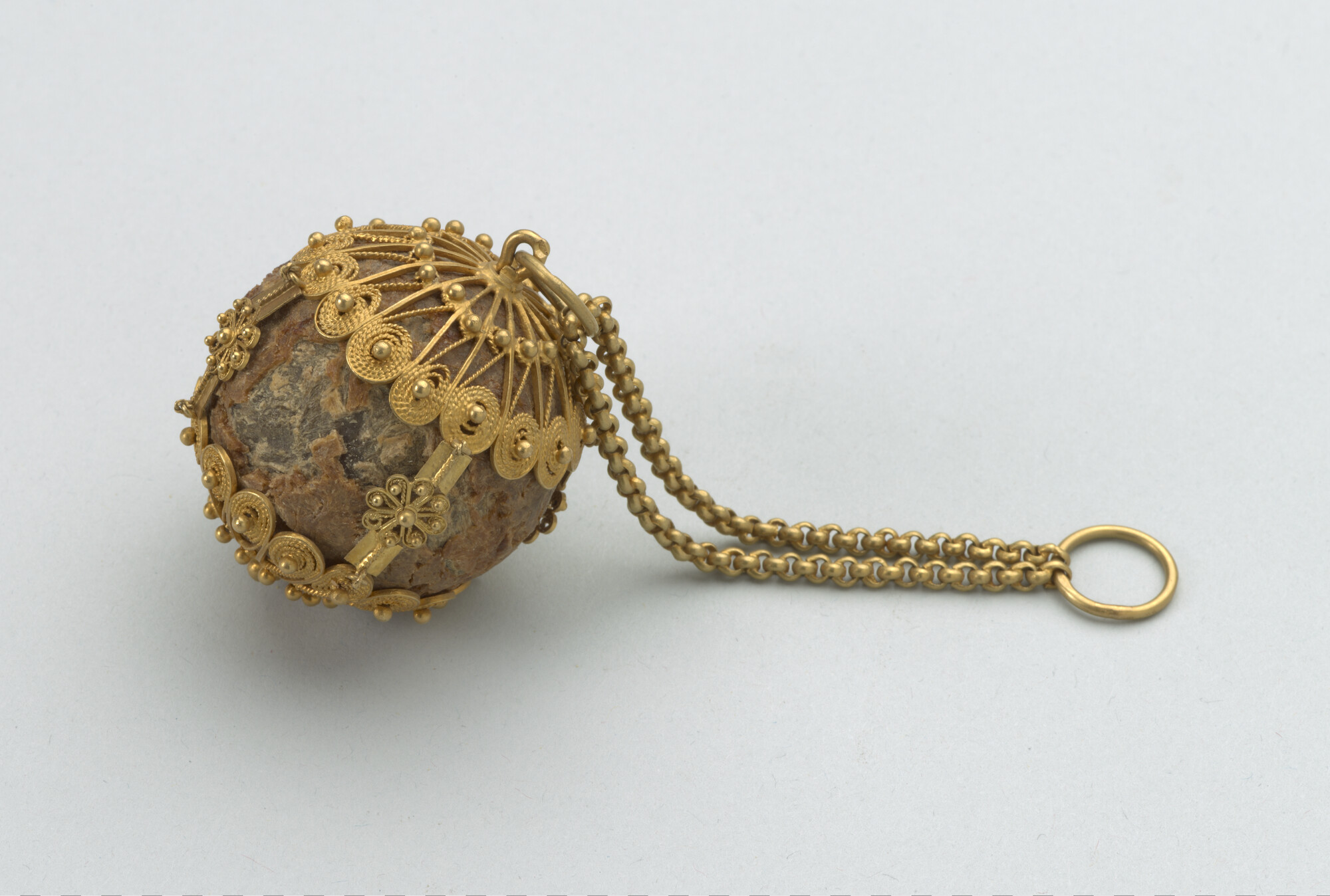 A.3873; Bezoarsteen, gevat in een zeventiende-eeuws gouden montuur; bezoarsteen