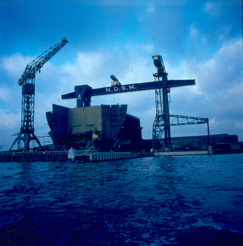 S.9100(3095); Dia (sfeerfoto) NDSM, 150-tons portaal-kraan met in aanbouw zijnde 'Melania'; diapositief