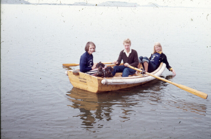 2014.0140; Dia van drie kinderen en twee honden aan boord van een roeivlet; kleurendia