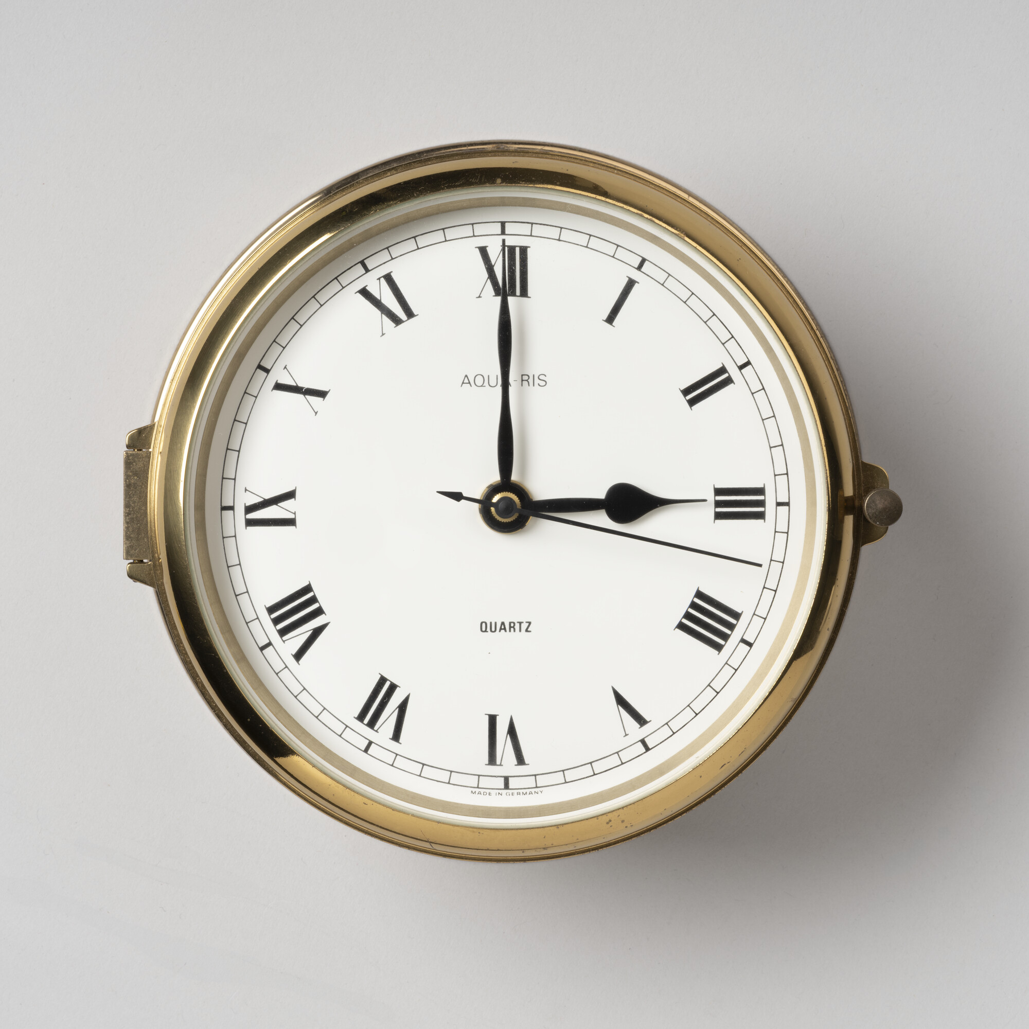 2005.2551; Ronde, geelmetalen klok met gebruiksaanwijzing; scheepsklok