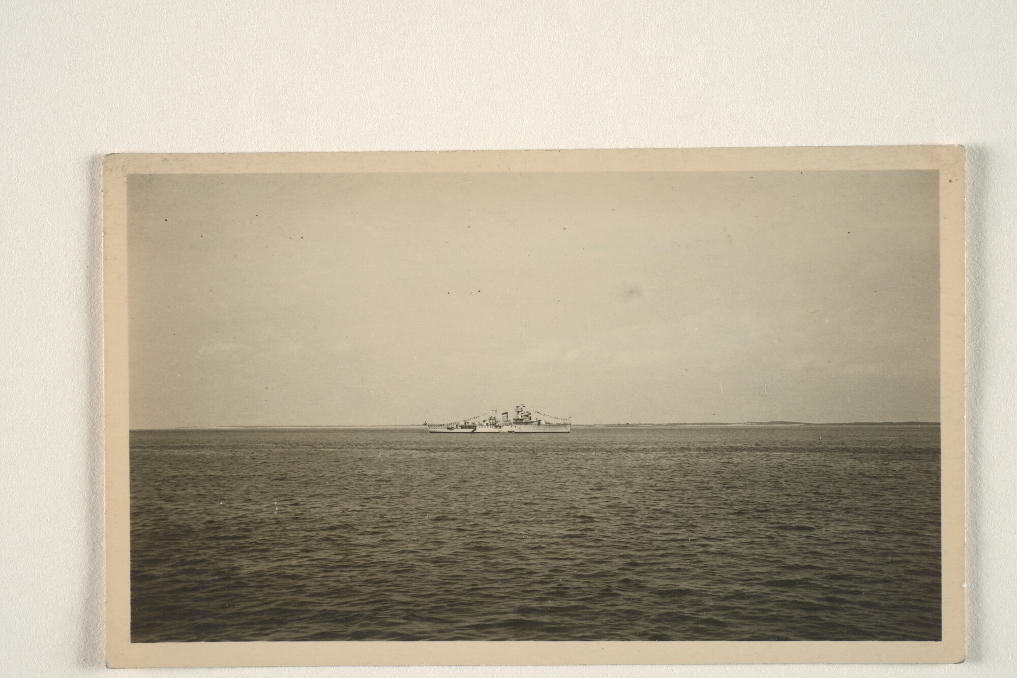 1995.1401; Het artillerie-instructieschip Hr.Ms. 'Van Kinsbergen' ligt voor anker op de Waddenzee, op de achtergrond is de kustlijn van Texel te zien; foto