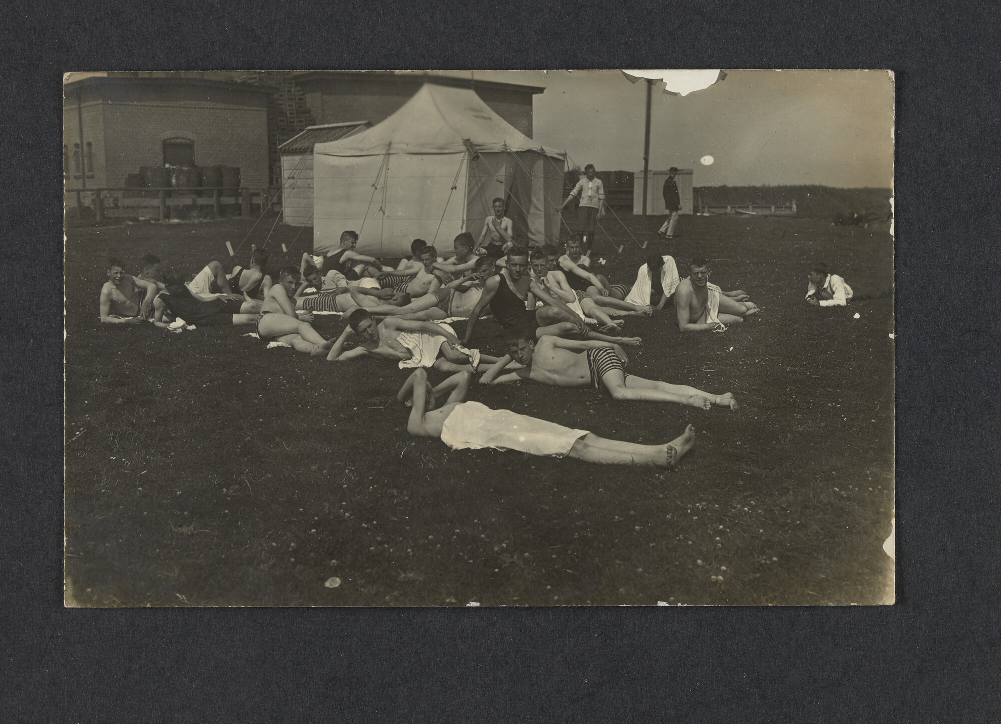 2022.0011; Zwart-wit foto van jongens liggend op een grasveld tijdens het eerste waterkamp voor jongens in Langweer (De Friese Meren) in 1915; foto