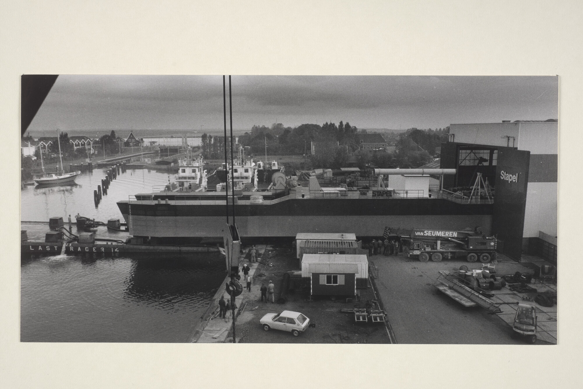 1998.0247; Het verrijden van een cutterzuiger uit een loods van scheepswerf Stapel in Spaarnedam op een zwarelading ponton [...]; foto