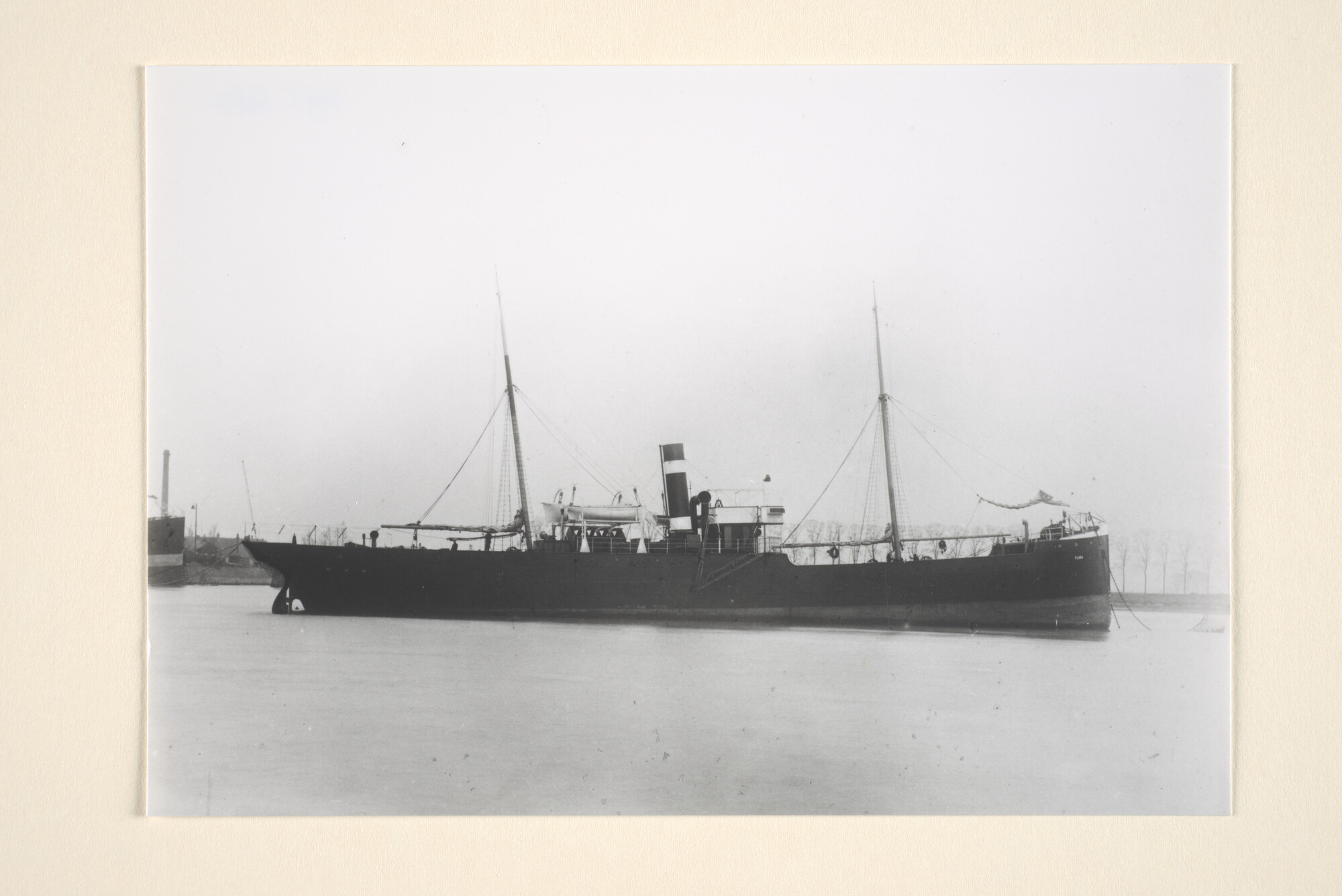 1995.6687; Het vrachtschip ss. 'Flora' van de KNSM ligt voor anker (vermoedelijk op het IJ te Amsterdam); foto