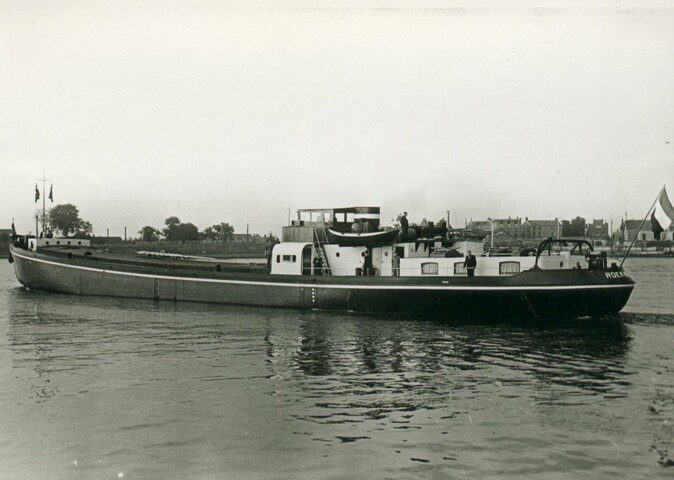 S.5219(12)0705; Foto's van het vrachtschip ms. Roekwijk van de Nieuwe Rijnvaart Maatschappij op een rivier en aan een kade; fotoreportage