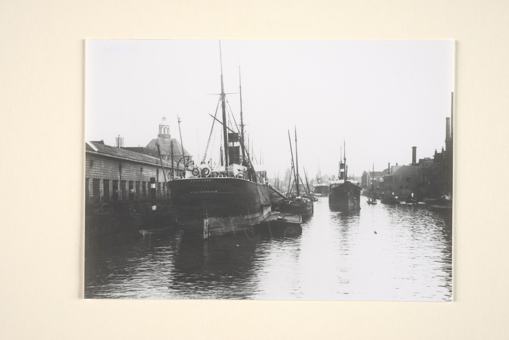 1995.6892; De Nieuwe Vaart te Amsterdam omstreeks 1902: links de goederenloods van de KNSM, met het vrachtschip ss. 'Penelope' afgemeerd langs de kade; foto