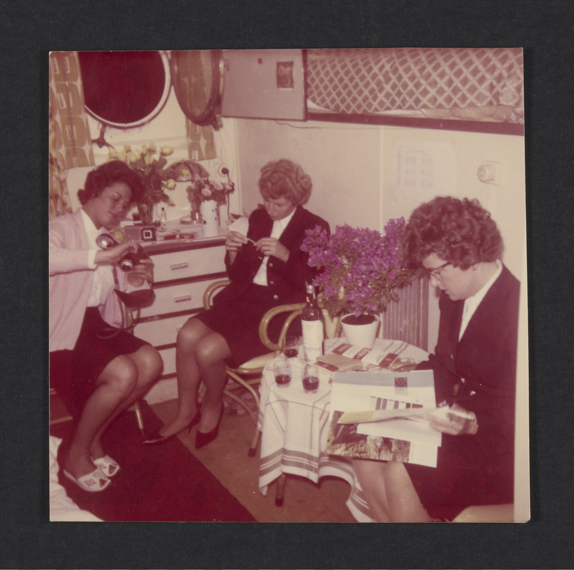2023.0454; Kleurenfoto van Freddie Knol, assistent purser a/b ms. Oranje, met collega's in een hut; foto